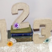 Burlap covered table numbers with lace and flower accents
