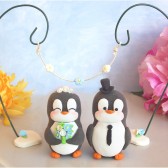Penguin cake topper with floral arc
