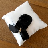 White satin ring pillow with black satin rosette