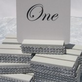 White wood table card holders trimmed with a crystal wrap