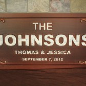 carved wooden established family name sign