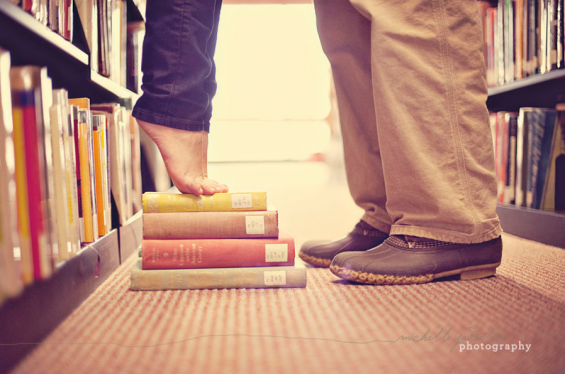 library engagement shoot standing on books