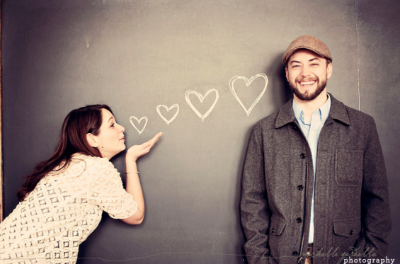 girl blowing kiss hearts on chalkboard engagement shoot chalkboard
