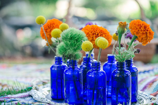 floral arrangements in blue bottles| Photo: White Ivory Photography | via https://emmalinebride.com/real-weddings/hipster-engagement-session-what-does-one-look-like/