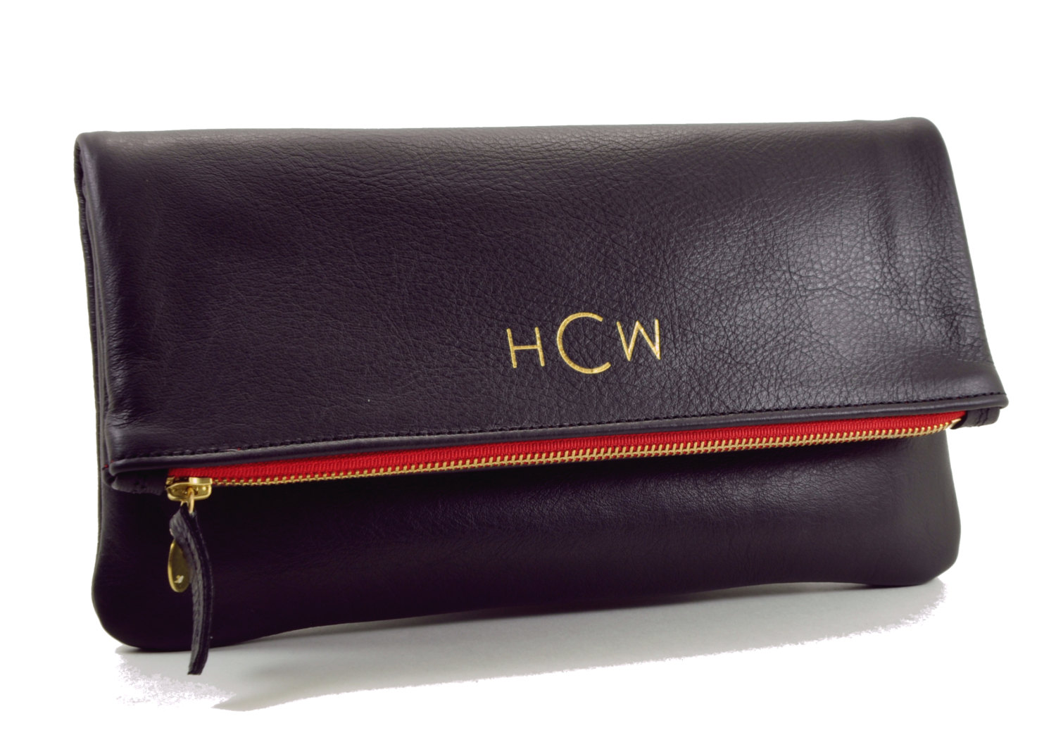 black foldover clutch with monogram in gold and red liner